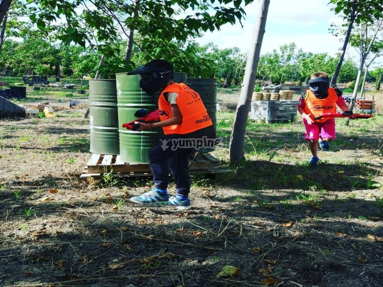 Jóvenes tras los bidones en la partida de gotcha Jóvenes tras los bidones en la partida de gotcha
