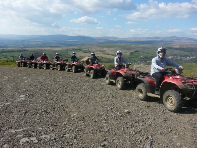  Personas con cascos blancos y sonriendo mientras manejan quads rojos