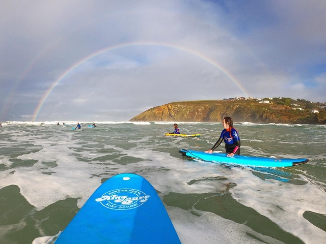  Surfistas vistiendo trajes azules y divirtiéndose surfeando 