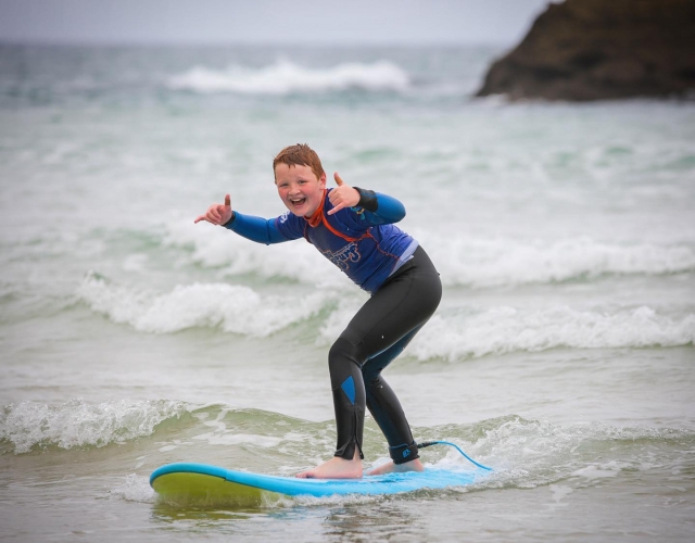  Chavo con traje azul surfeando y divirtiéndose