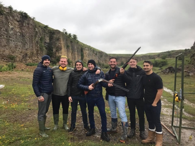  Grupo de amigos con chaquetas negras y grises, sonriendo y haciendo jalo con palomas