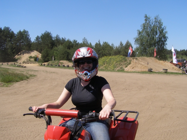 Mujer con casco blanco y rojo duranle su sesión de cuatrimoto 