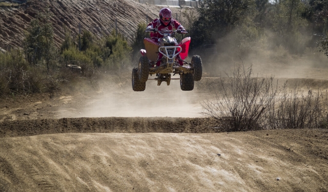  Aventurero con casco rojo y traje saltando con quad