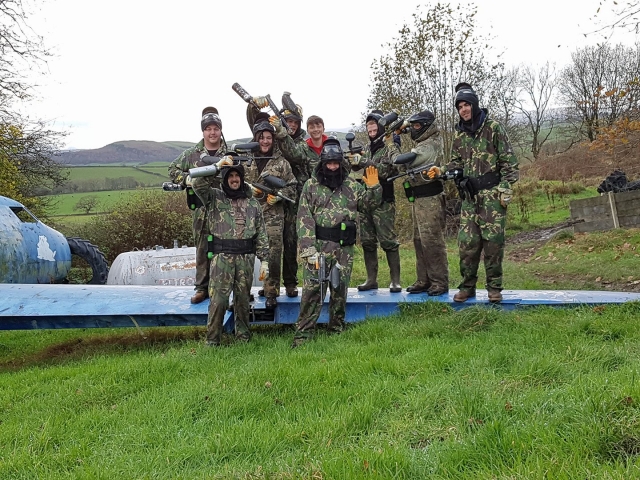  Grupo de amigos con traje de camuflaje practicando gotcha 