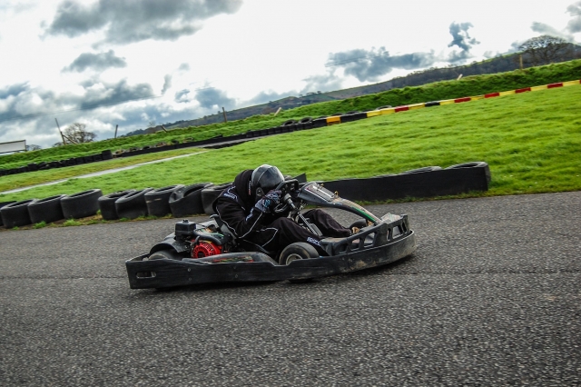  Conductor con casco negro y traje de conducción Karting 