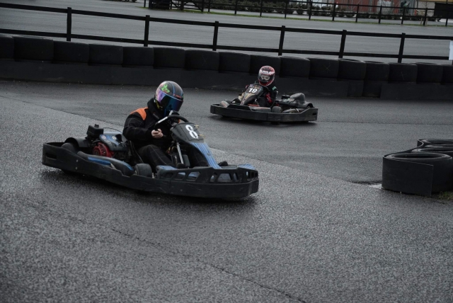  Dos personas que usan casco negro y trajes de conducción Karting 