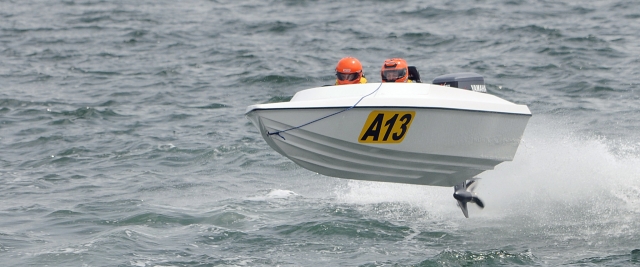  Lancha blanca y dos personas aprendiendo a manejar la embarcación 