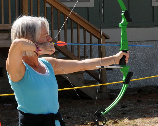  Mujer haciendo jalo con arco con flecha verde