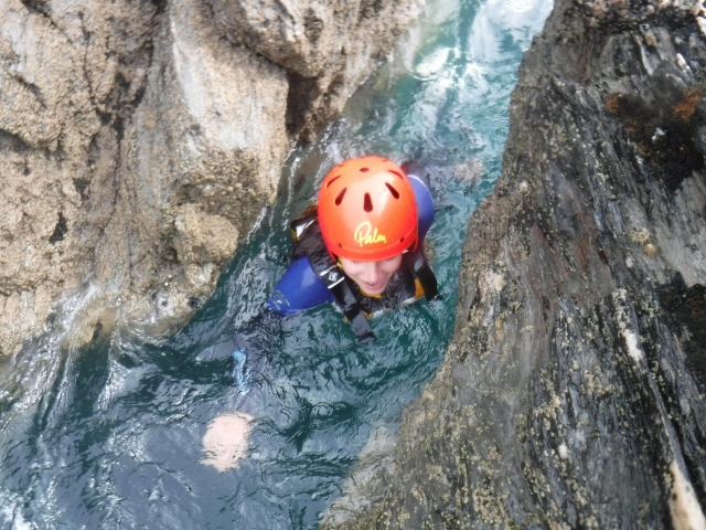  Mujer con casco rojo mientras coasteering 