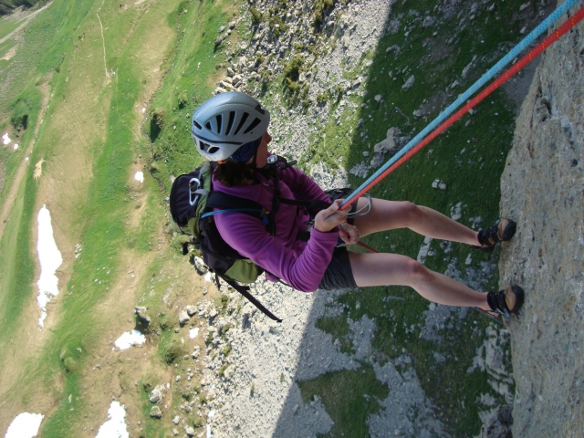  Mujer con chamarra morada y casco subiendo la cerro 