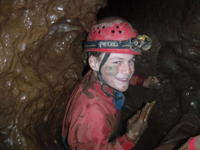  Niño sonriendo y divirtiéndose mientras espeleología