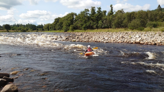  Niño navegando en kayak en el río con casco blanco y ayudas a la flotabilidad rojas 
