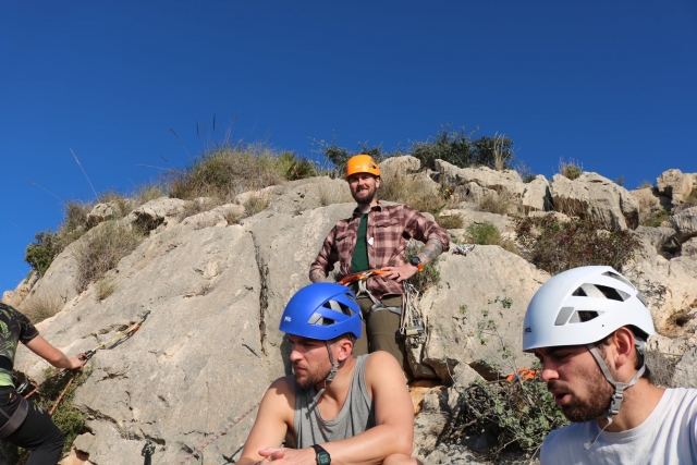 Tres hombres con cascos y escalando 