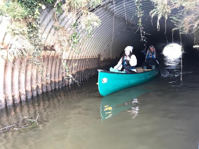  Dos niñas navegando en el río en una canoa azul 