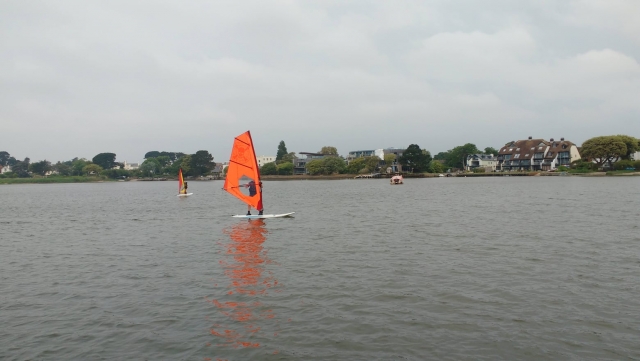  Personas practicando wingsurf en tablas de wingsurf naranjas 