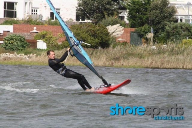  Niño con traje de neopreno negro y windsurf