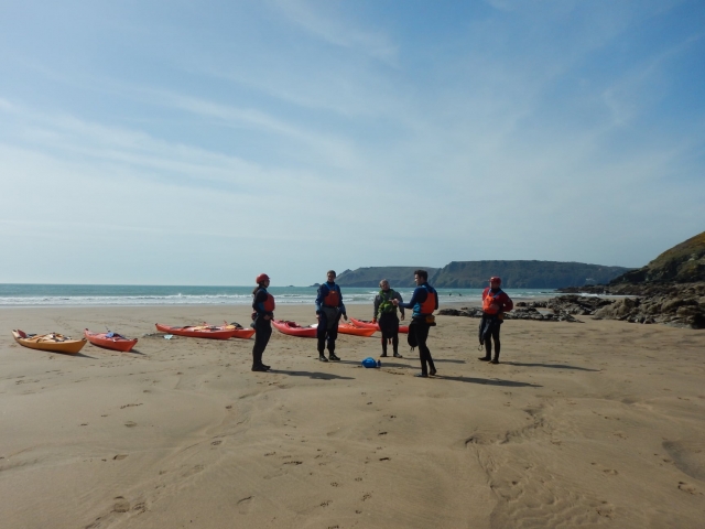  Grupo vistiendo rojo ayudas a la flotabilidad preparándose para kayak