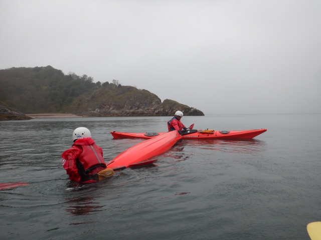  Dos personas vestidas con rojo ayudas a la flotabilidad y trajes de neopreno kayak en kayaks rojos 