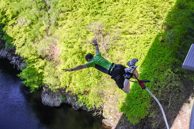  Hombre con playera verde mientras Bungee Jumping 