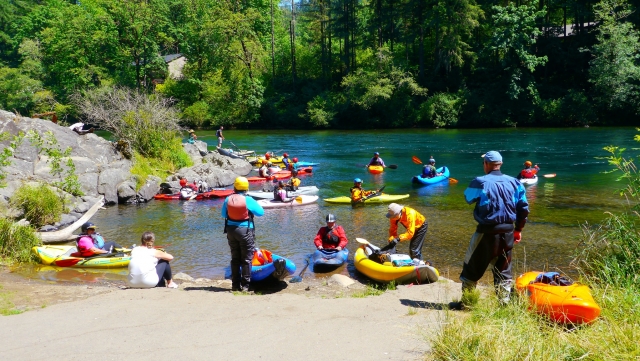  Personas vistiendo equipos coloridos antes de hacer kayak 
