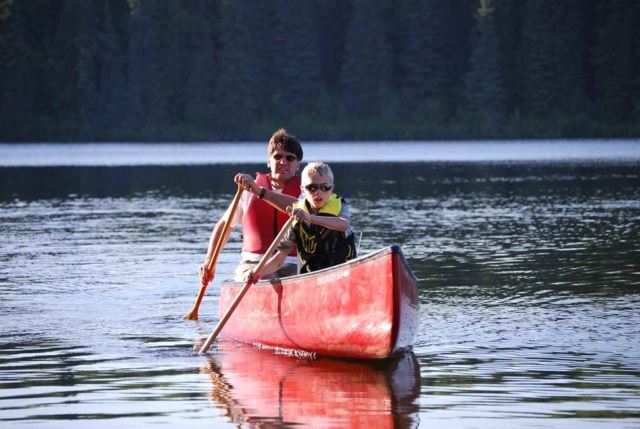  Hombre y niño remar un deporle canoa 