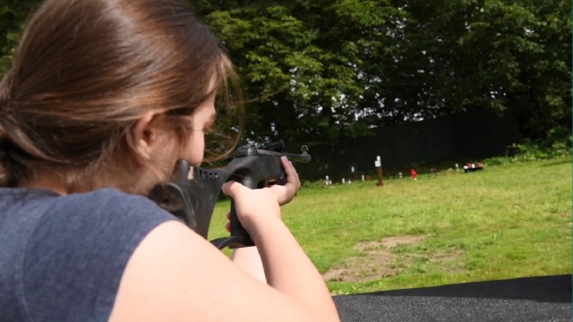  Chica en playera negra practicando jalo con rifle 