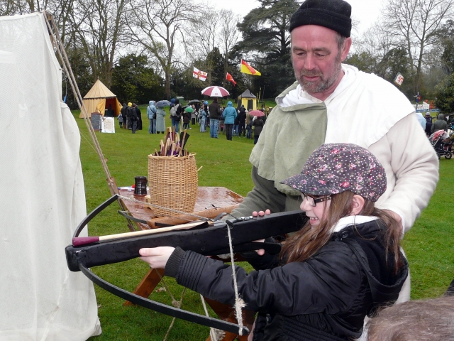  Chica chavo en chamarra negra practicando jalo con arco con ballesta 