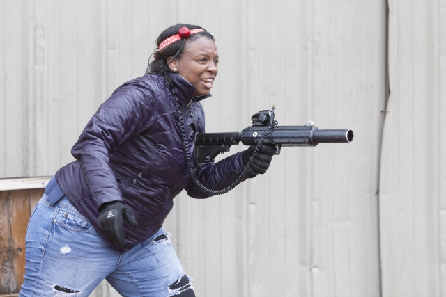  Mujer corriendo y riendo mientras juega laser tag 