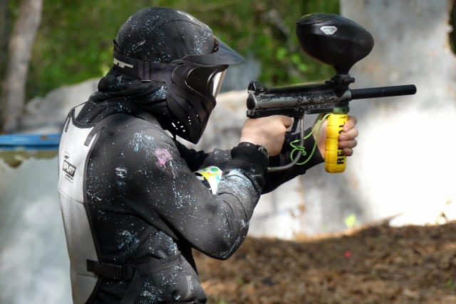  Niño jugando gotcha con máscara y traje negros 