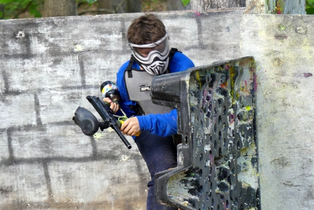  Niño jugando gotcha con traje azul y máscara gris 