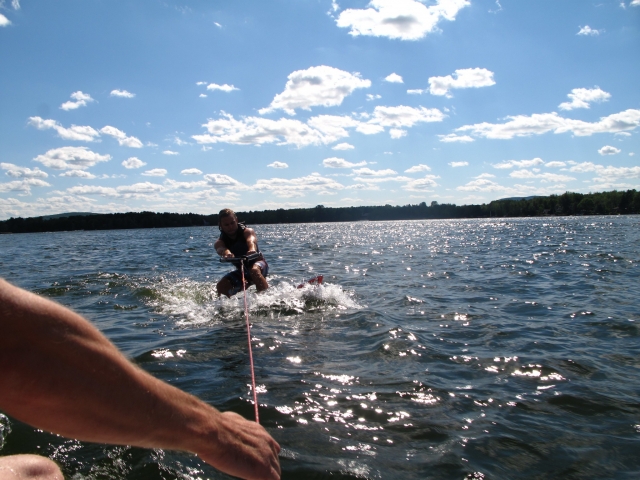 Instructor ayudando a aventurero a hacer wake surf