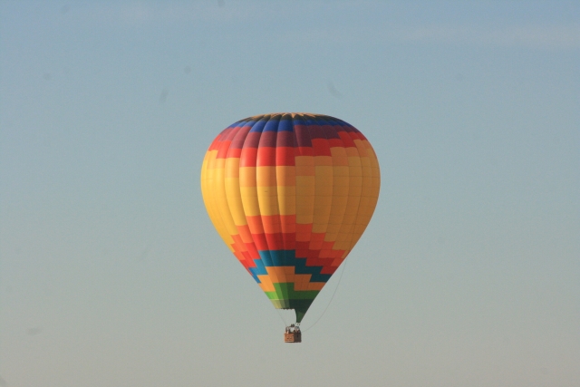  Globo amarillo, naranja y azul volando sobre Dorset
