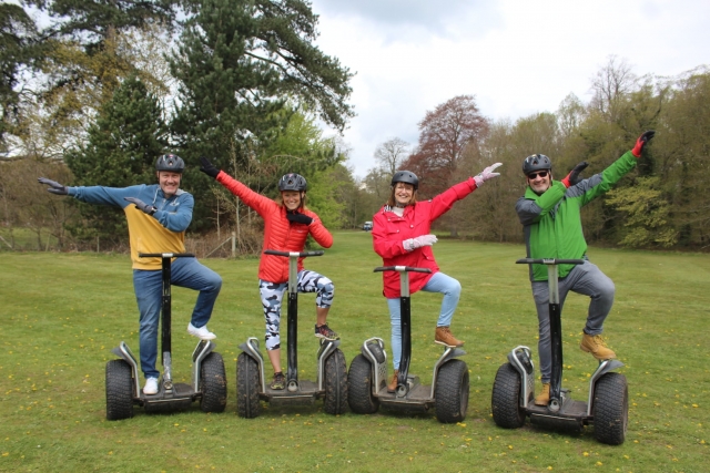  Amigos con cascos negros y levantando los brazos antes de hacer segway 