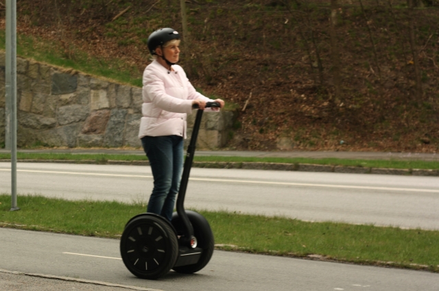  Chica con suéter blanco y casco negro duranle su sesión de segway 