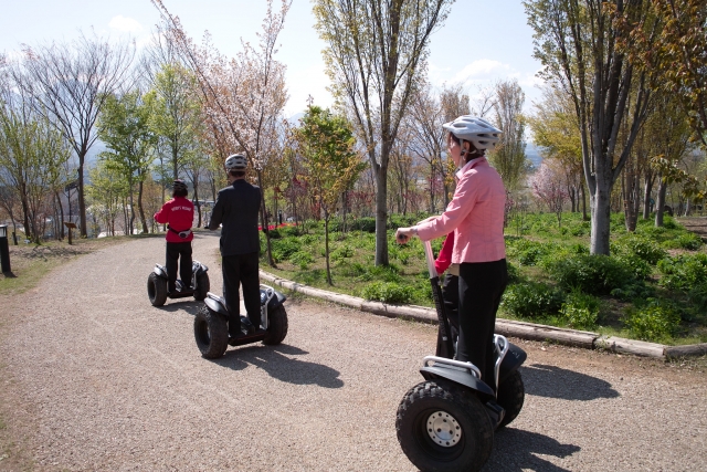  Mujer con suéter rosa con sus amigos duranle su sesión de segway 