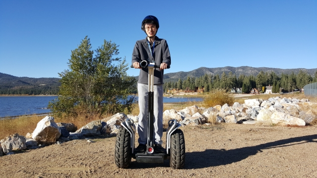  Hombre sonriendo, con casco negro haciendo segway
