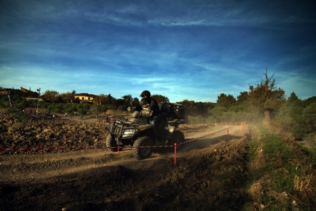  Aventurero con traje y casco negros recorriendo el terreno en cuatrimotos 