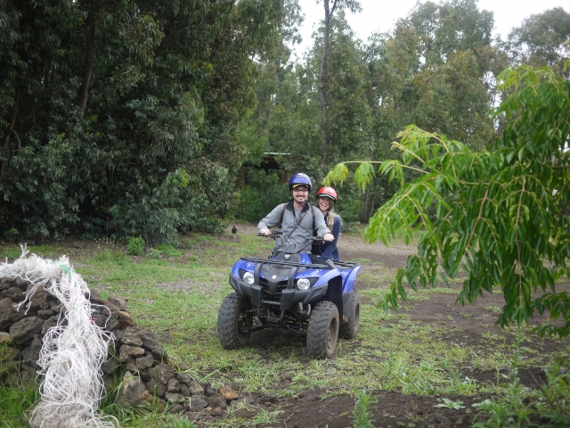 Pareja sonriendo y usando cascos azules y naranjas en quad