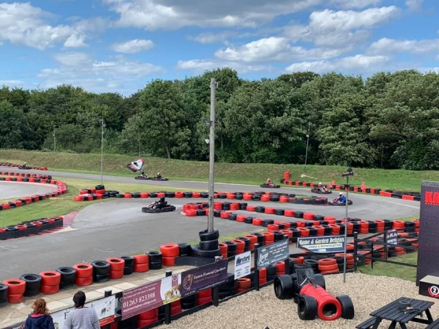 Niños de 8 años practicando karting con nosotros con trajes negros