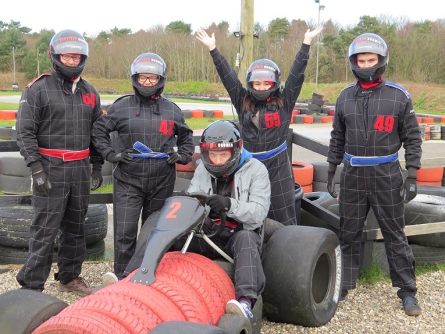 Amigos con traje de conducción negro divirtiéndose antes del karting