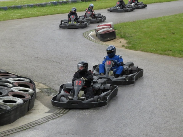 Grupo de personas manejando karts negros