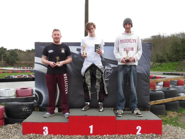 Chico con mono de conducción blanco, ganador de la carrera