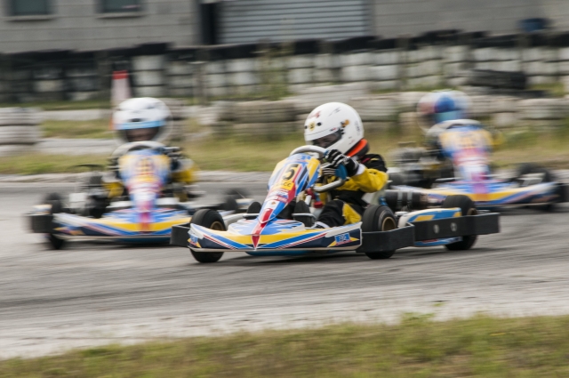  Conductor con traje de conducción azul manejando rápido duranle la carrera de karting