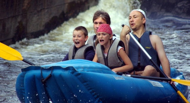  Familia con una niña y un niño divirtiéndose mientras hacen rafting en el río Findhorn