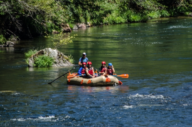 Grupo de personas vestidas de azul y rojo equipo duranle el rafting