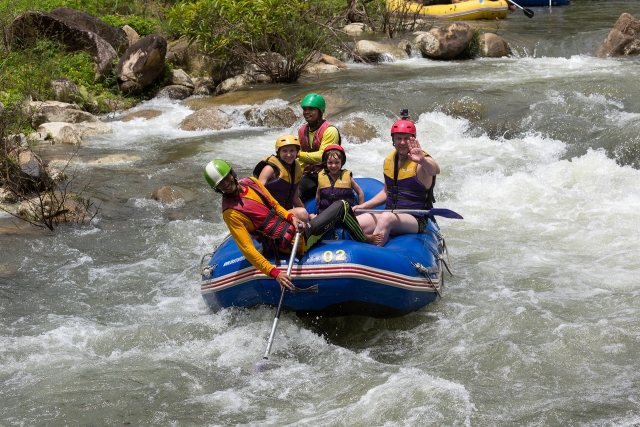  Una familia usando equipo amarillo y azul haciendo rafting en el río Findhorn 