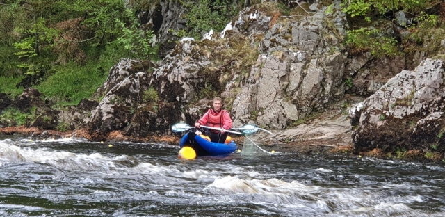  hombre con equipo rojo haciendo rafting en el río Tay 