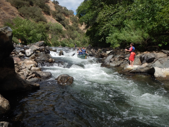 Niños vistiendo trajes de neopreno azules y rojos mientras hace Coasteering