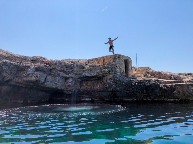 Niño saltando desde un acantilado mientras hace Coasteering con nosotros