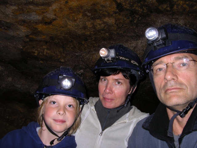 Familia con cascos azules y ropa cómoda para espeleología 